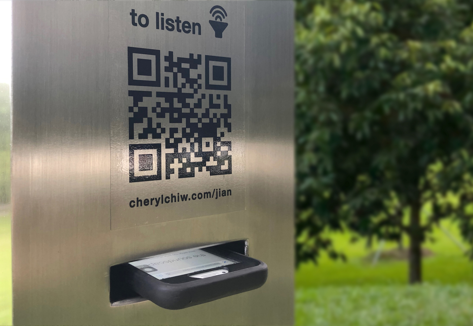 A phone placed in the slot of jian rewritten, the sculpture @ Punggol Waterway Park, slot for phone playing soundscape